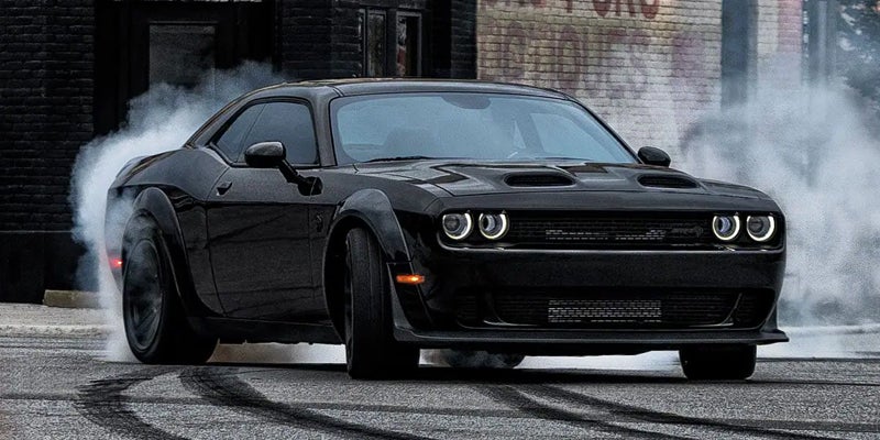 Black Dodge Challenger SRT doing a smoky burnout