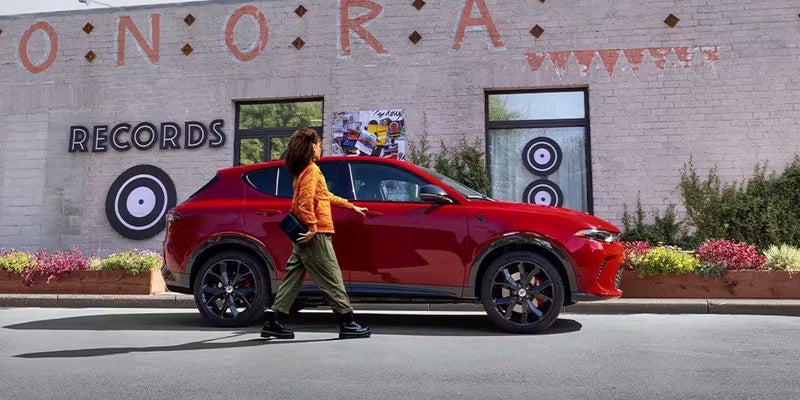 A women is opening door of red hornet car